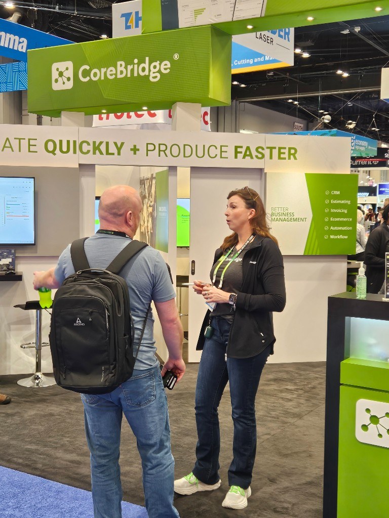 CoreBridge team talking with a visitor at the expo booth