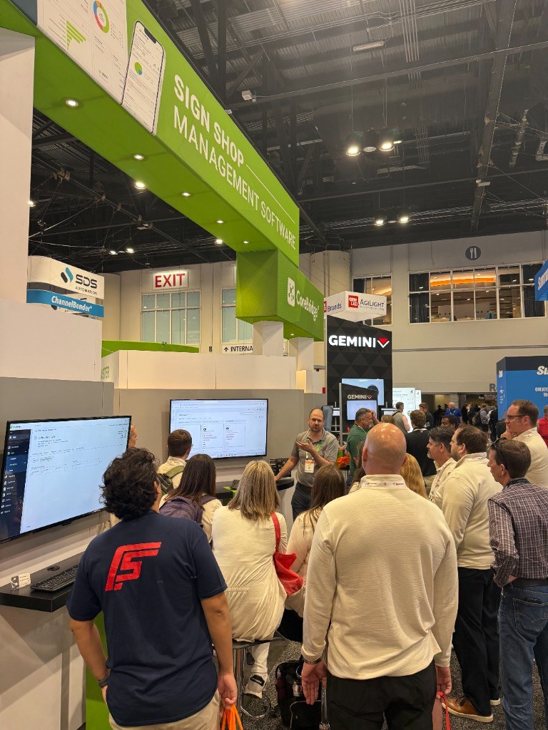 A group gathered for a live CoreBridge demo at the booth